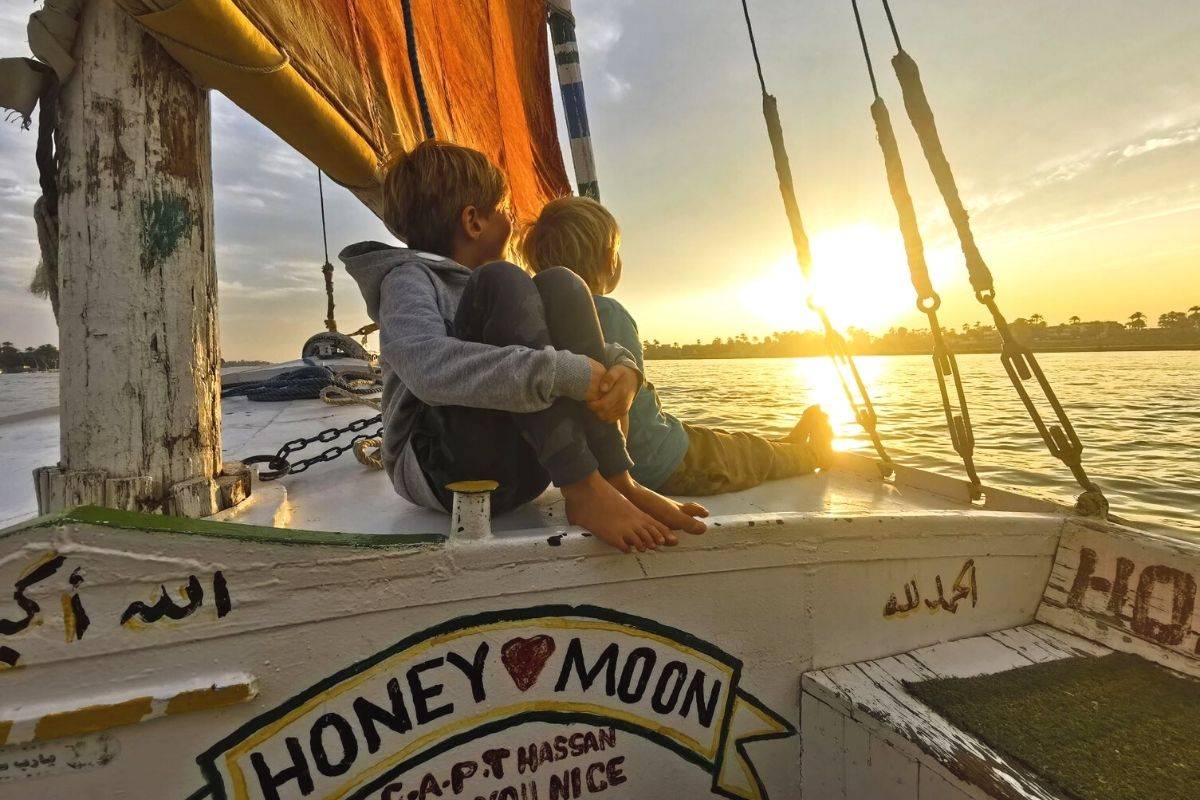 Two boys enjoying a sunset felucca trip down the Nile in Luxor