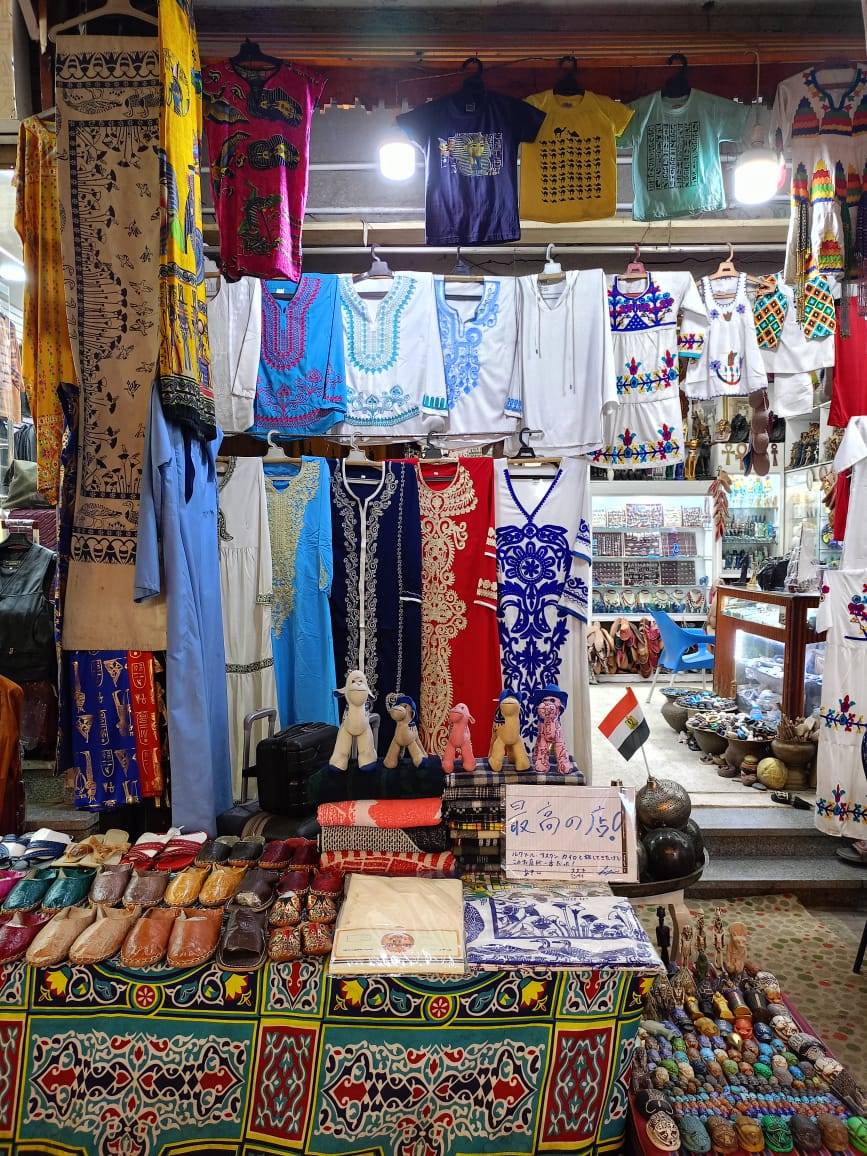 Galabeyas de colores colgadas en un puesto del zoco de Luxor