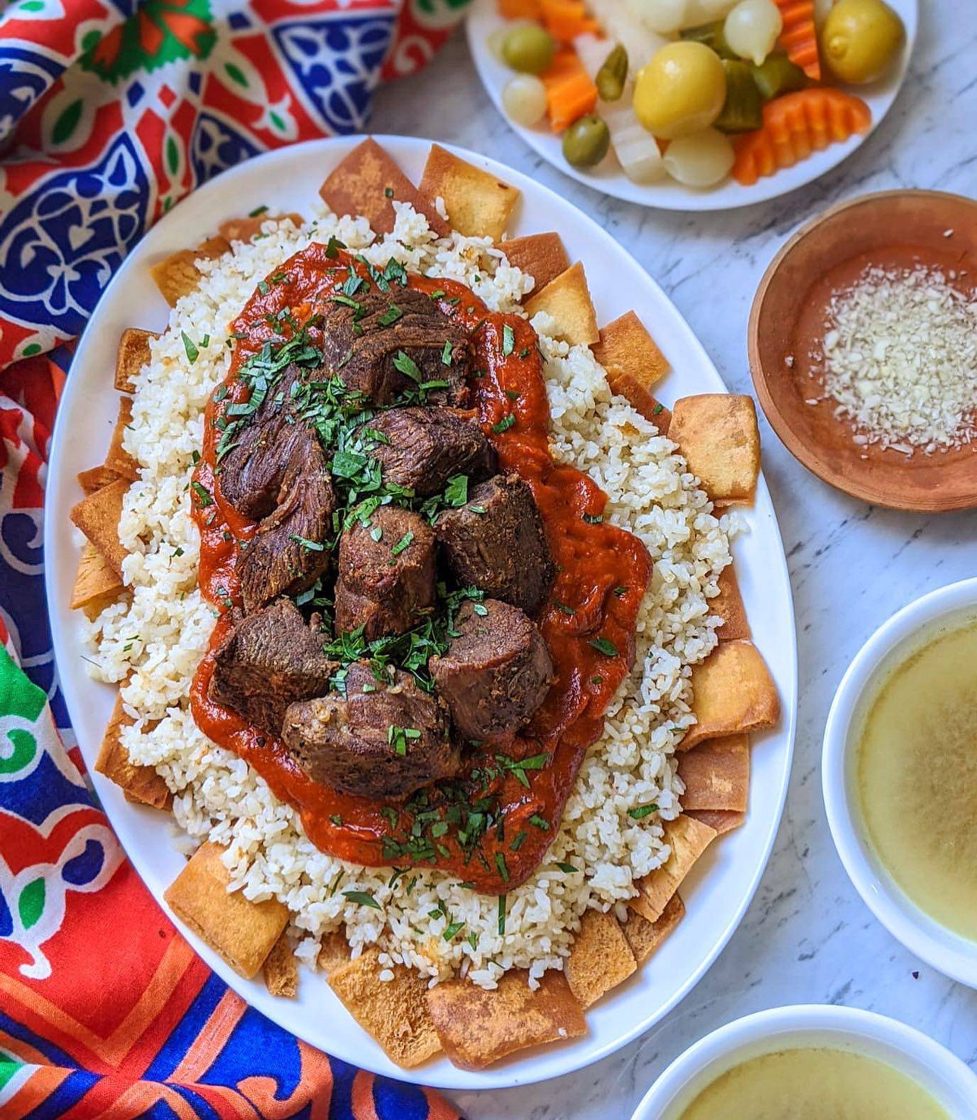 Egyptian Fattah served in a large communal dish with layered bread, rice, and meat