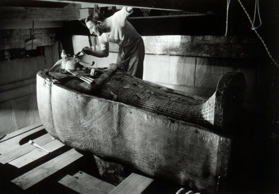 Howard Carter brushing dust off King Tut's mummy