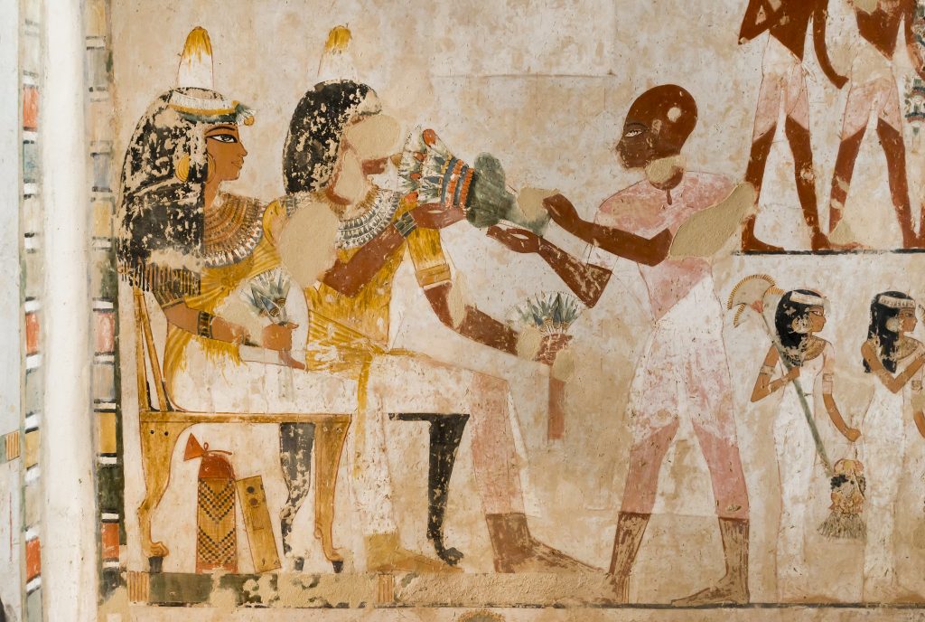 Menna and his wife Henuttawy, seated, receiving a multicoloured bouquet from a man with shaven head