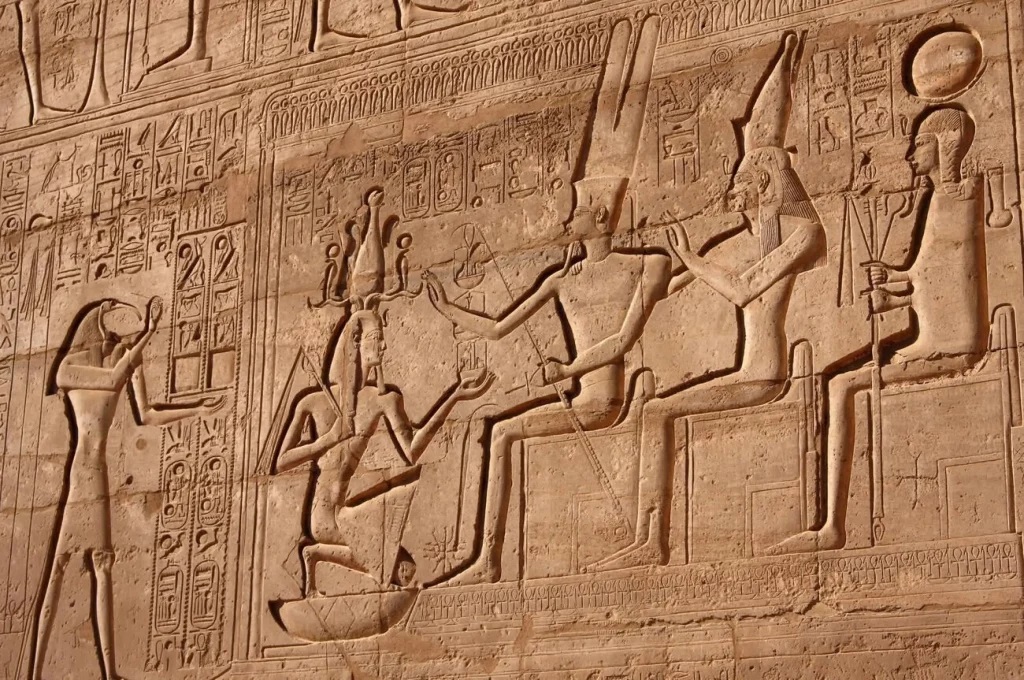Relief of Ramses II kneels in front of Amon, Mut, and Khonsu on the Ramesseum