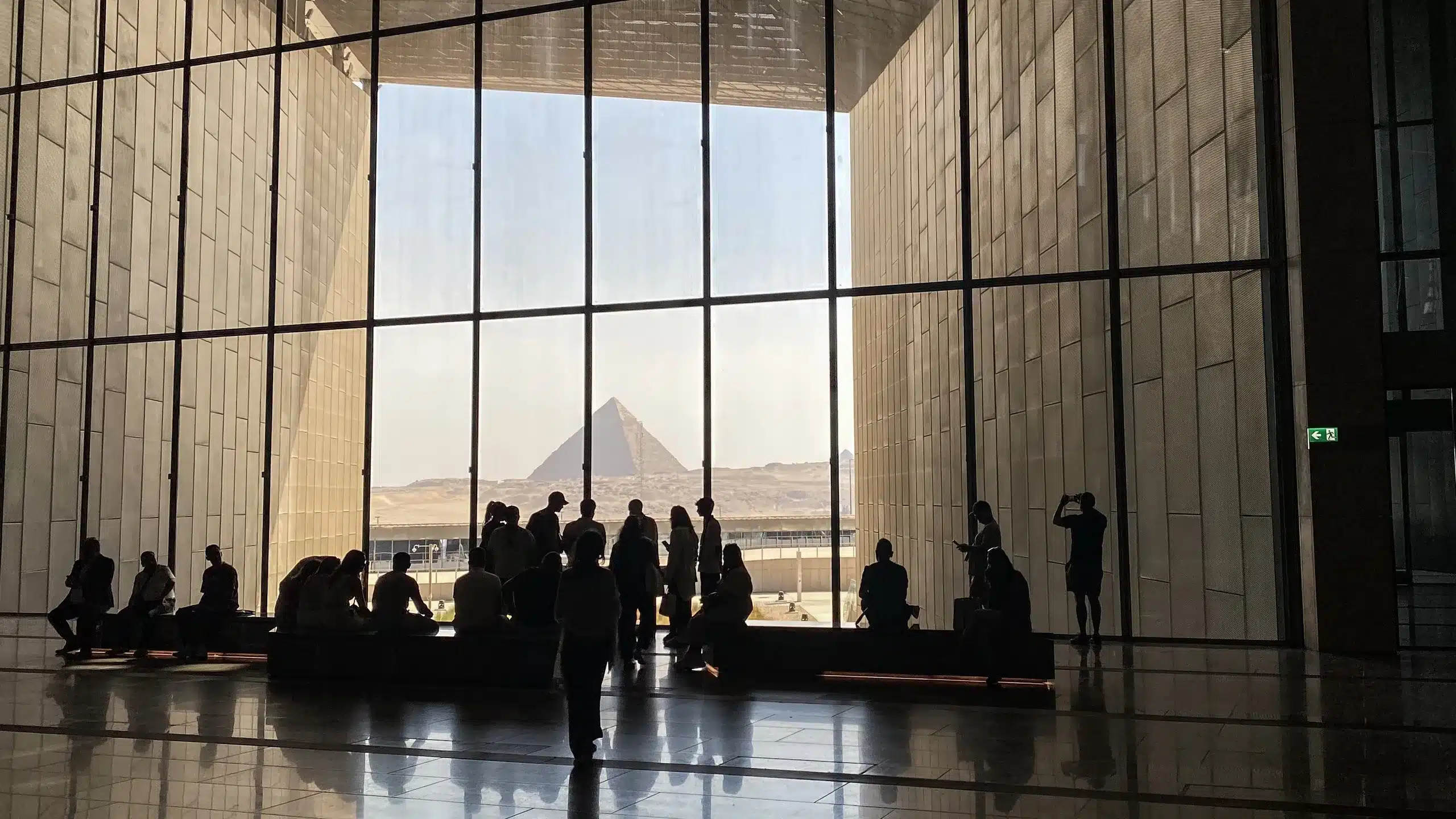 The Grand Egyptian Museum's glass front framing the Giza pyramids