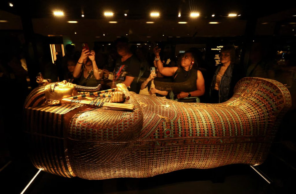 Visitors look at the golden coffin of ancient Egyptian Pharaoh Tutankhamun