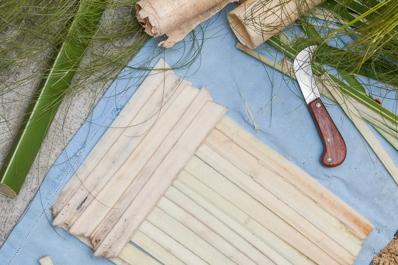 Artisan weaving strips of papyrus pith in a traditional workshop